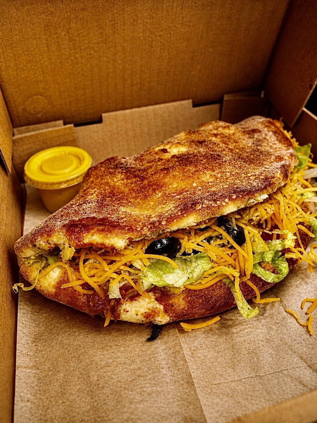 Stuffed calzone style item in a pizza box
